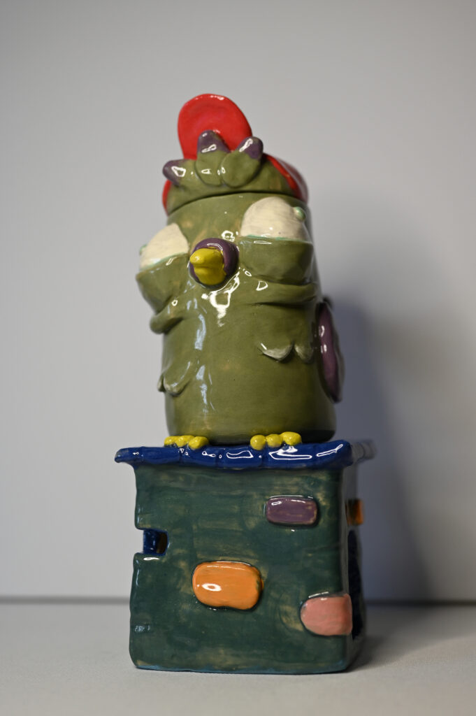 Detail of Pigeons' Save Space by Fatin Rahmouni showing the hand-modelled features and glazed surface of the ceramic pigeon.